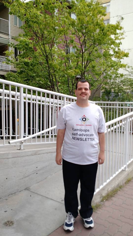 Krystian Shaw, of the Kamloops Self-Advocate Newsletter stands in front of an accessibility ramp in the community of Kamloops.